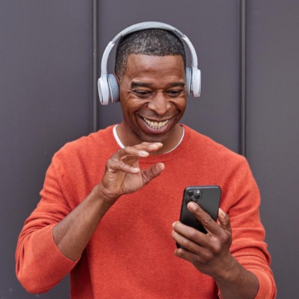 Person wearing a work headset uses VoIP technology on their mobile device.